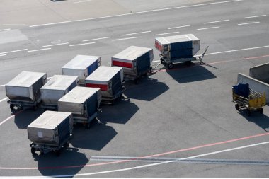 Modern standartlaştırılmış normlu alüminyum metal havaalanı havacılık kargo kargo konteynırlarının daha önceki zamanlardan kalma antika bir bagaj vagonunun yanına yakın plan konsepti.