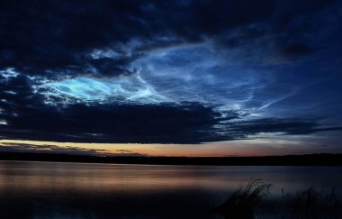 Harika bir yaz akşamı ve gölün arka planında gümüş bulutlar.
