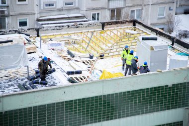 İnşaatçılar çatıda tadilat yapıyor.