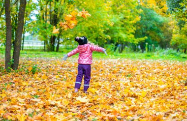 Bir kız bir sürü sarı akçaağaç yaprağı kusar.