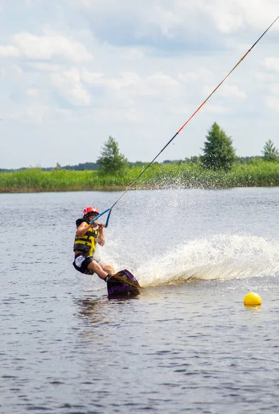 Boy age 9 riding wakeboard on lake — Stock Photo, Image