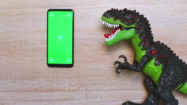 携帯電話のクロマキー恐竜のプラスチック製のおもちゃの移動と言う — ストック動画
