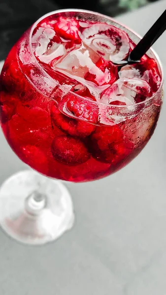 Tropical cooling cocktail with raspberries and with ice