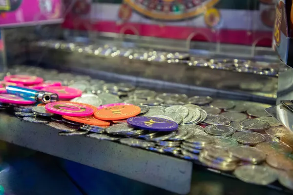 Máquina empujadora de monedas con un montón de monedas —  Fotos de Stock