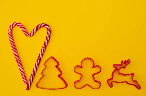 Noel lolipopları ve noel kurabiyesi kesicileriyle dolu bir kalp. — Stok fotoğraf