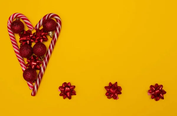 Christmette Flatlay Herz mit Lutschern gefüttert und mit Weihnachtsbaumspielzeug dekoriert — Stockfoto