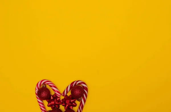 Flatlay Teil eines Herzens, das mit Weihnachtslutschern gefüttert und mit Weihnachtsbaumspielzeug verziert ist — Stockfoto