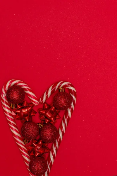 Coeur flatlay Christmass doublé de sucettes de Noël et décoré avec des jouets d'arbre de Noël — Photo