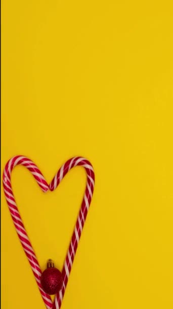 Corazón plano de Navidad forrado con piruletas de Navidad y decorado con juguetes de árbol de Navidad — Vídeos de Stock