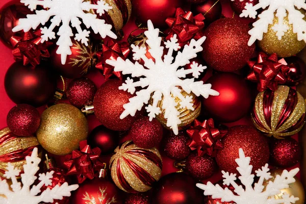 Рождественские елочные игрушки красного цвета и белые снежинки — стоковое фото