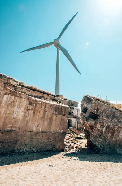 stock image Windmill for electricity generation and ruins of the sea fort in Liepaja