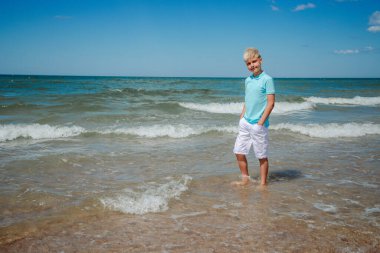 Plajda yaz tatili yapan genç bir çocuk.