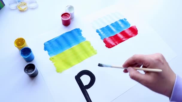 A woman paints a poster with the flag of Ukraine and of Russia and text Peace — Stock Video