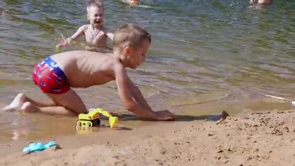 Happy boy playing with beach toys in the lake sunny summer day, Marupe, Lettország - 07 július 2021 — Stock videók