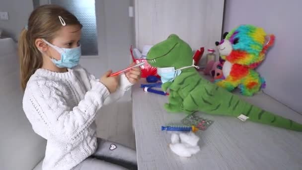 A girl plays doctor treats dinosaur toy — Stok video