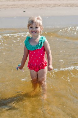 Girl of European appearance having fun in water on the beach 
