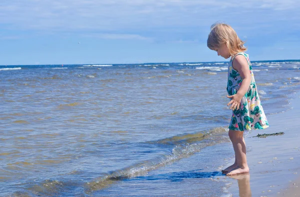 Dziewczynka spacerująca samotnie po plaży w letni słoneczny dzień — Zdjęcie stockowe