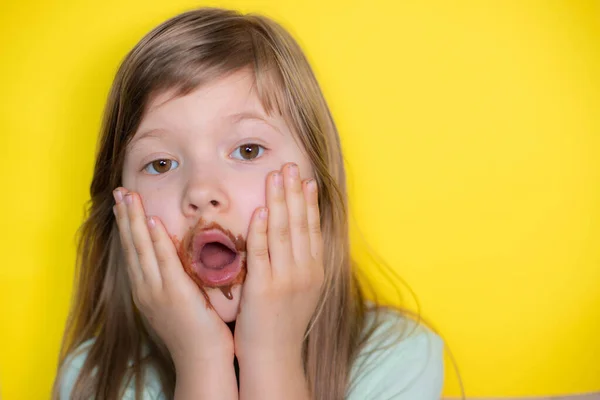 Frightened little girl eating chocolate dirty face