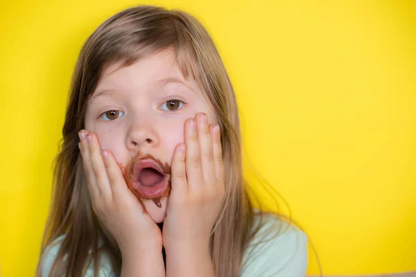 Налякана маленька дівчинка їсть шоколад брудне обличчя Стокова Картинка