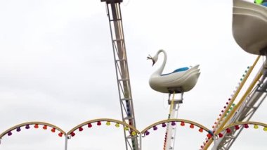 Çocuk atlıkarınca lunaparkta hareket halindeki kuğular için. Çocuklarla tatil, çocuklarla hafta sonları, çocuklarla tatiller. Yüksek kaliteli FullHD görüntüler
