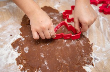 Çocuk elleri zencefilli kurabiye hamuru ve kurabiye kesiciden Noel kurabiyesi yapıyor. Noel kartı ve takvim kavramı. Kapat. Yüksek kalite fotoğraf