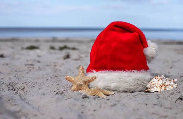 Natale Sfondo Cappello Babbo Natale Sulla Spiaggia Con Stelle Marine — Foto Stock