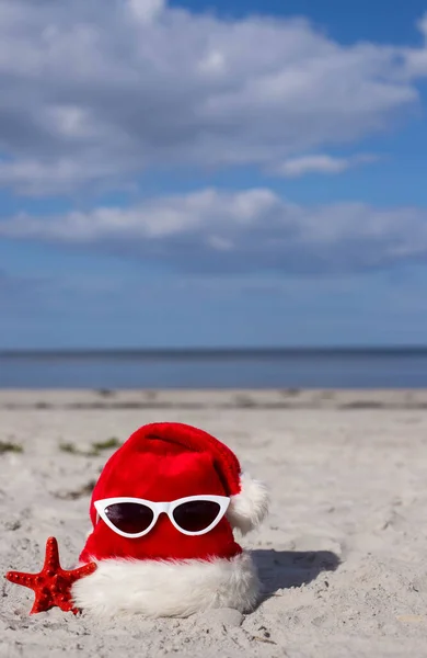 Karácsonyi Háttér Mikulás Kalap Tengeri Csillag Napszemüvegek Homokos Strandon Karácsonyi — Stock Fotó