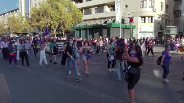Женщины маршируют и демонстрируют баннеры на Международном женском дне 8M - Сантьяго, Чили - 8 марта 2022 года — стоковое видео