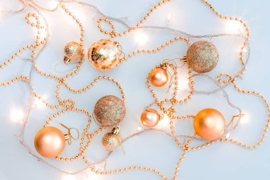 Noel kompozisyonu, altın noel süslemeleri ve sarı arka planda ışık ve metin için fotokopi alanı olan çelenkler. Görüntü. Düz yatıyordu. Kış, kartpostal şablonu.