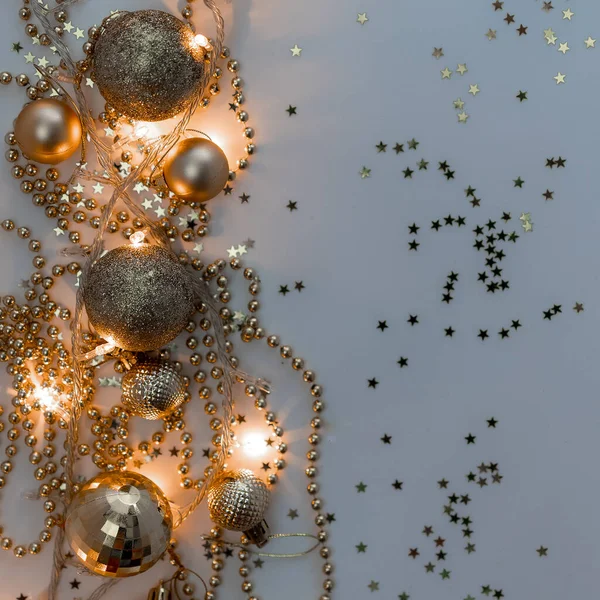 Noel kompozisyonu, altın noel süslemeleri ve sarı arka planda ışık ve metin için fotokopi alanı olan çelenkler. Görüntü. Düz yatıyordu. Kış, kartpostal şablonu.