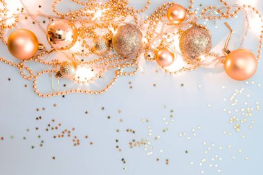 Noel kompozisyonu, altın noel süslemeleri ve sarı arka planda ışık ve metin için fotokopi alanı olan çelenkler. Görüntü. Düz yatıyordu. Kış, kartpostal şablonu.