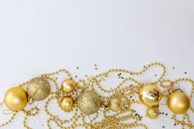 Noel kompozisyonu, altın noel süslemeleri ve sarı arka planda ışık ve metin için fotokopi alanı olan çelenkler. Görüntü. Düz yatıyordu. Kış, kartpostal şablonu.