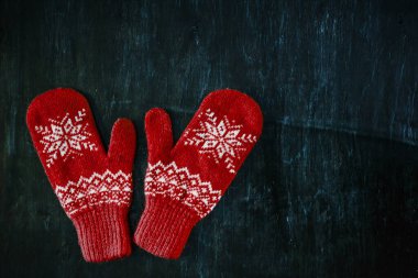 Bir çift kırmızı-pembe-eflatun-mor eldiven koyu mavi-yeşil-kahverengi ahşap bir arka planda, kopyalama alanı.