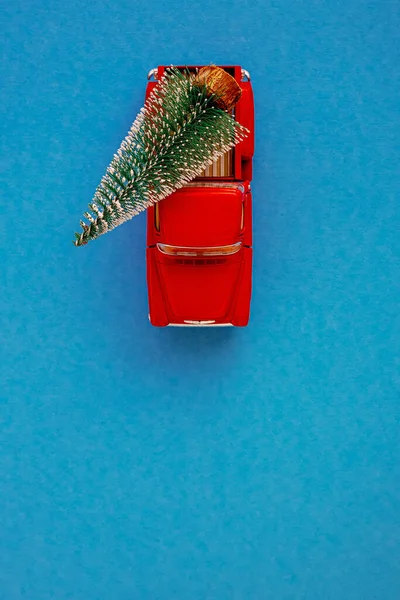 Ένα Μικροσκοπικό Κόκκινο Αυτοκίνητο Στο Πίσω Μέρος Μεταφέρει Ένα Χριστουγεννιάτικο — Φωτογραφία Αρχείου