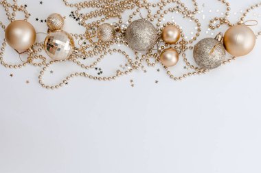 Noel kompozisyonu, altın noel süslemeleri ve sarı arka planda ışık ve metin için fotokopi alanı olan çelenkler. Görüntü. Düz yatıyordu. Kış, kartpostal şablonu.