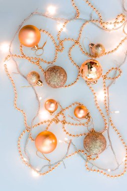 Noel kompozisyonu, altın noel süslemeleri ve sarı arka planda ışık ve metin için fotokopi alanı olan çelenkler. Görüntü. Düz yatıyordu. Kış, kartpostal şablonu.