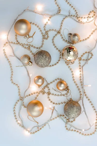 Noel kompozisyonu, altın noel süslemeleri ve sarı arka planda ışık ve metin için fotokopi alanı olan çelenkler. Görüntü. Düz yatıyordu. Kış, kartpostal şablonu.