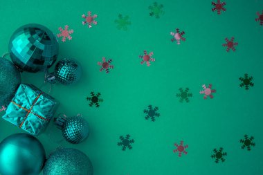 Noel kompozisyonu, yeşil renkli üst manzara ve yeşil arkaplan üzerine yeşil Noel süslemeleri ve metin için fotokopi alanı. Düz yatıyordu. Kış, kartpostal şablonu.