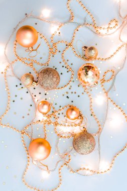 Noel kompozisyonu, altın noel süslemeleri ve sarı arka planda ışık ve metin için fotokopi alanı olan çelenkler. Görüntü. Düz yatıyordu. Kış, kartpostal şablonu.