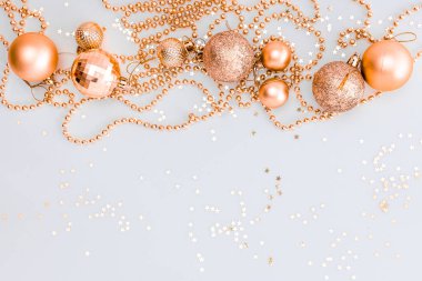 Noel kompozisyonu, altın noel süslemeleri ve sarı arka planda ışık ve metin için fotokopi alanı olan çelenkler. Görüntü. Düz yatıyordu. Kış, kartpostal şablonu.