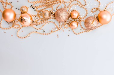Noel kompozisyonu, altın noel süslemeleri ve sarı arka planda ışık ve metin için fotokopi alanı olan çelenkler. Görüntü. Düz yatıyordu. Kış, kartpostal şablonu.