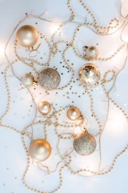 Noel kompozisyonu, altın noel süslemeleri ve sarı arka planda ışık ve metin için fotokopi alanı olan çelenkler. Görüntü. Düz yatıyordu. Kış, kartpostal şablonu.