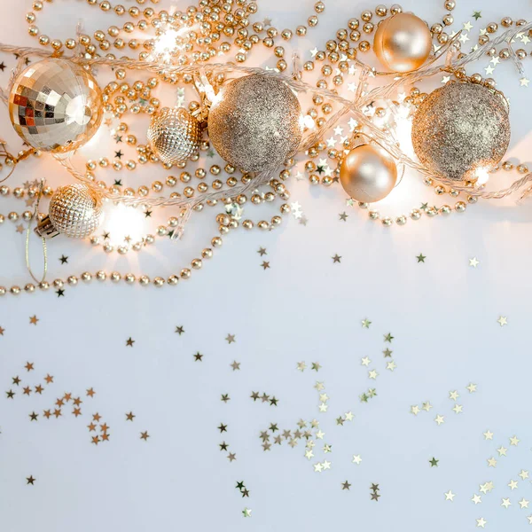 Noel kompozisyonu, altın noel süslemeleri ve sarı arka planda ışık ve metin için fotokopi alanı olan çelenkler. Görüntü. Düz yatıyordu. Kış, kartpostal şablonu.