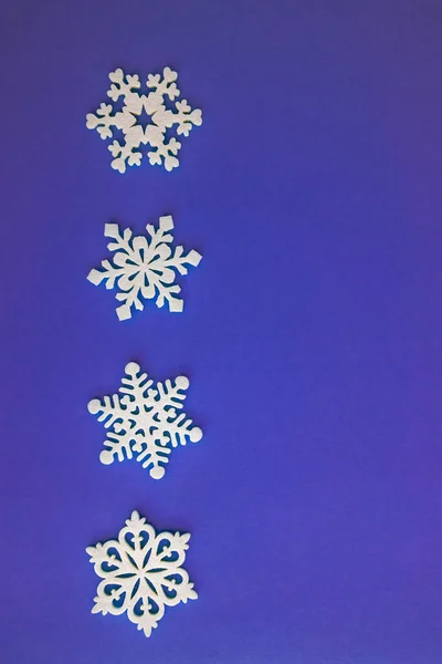 Composition vacances de Noël, vue de dessus décoration de flocons de neige blancs sur fond violet-lilas avec espace de copie pour le texte. Pose plate. Hiver, modèle de carte postale — Photo