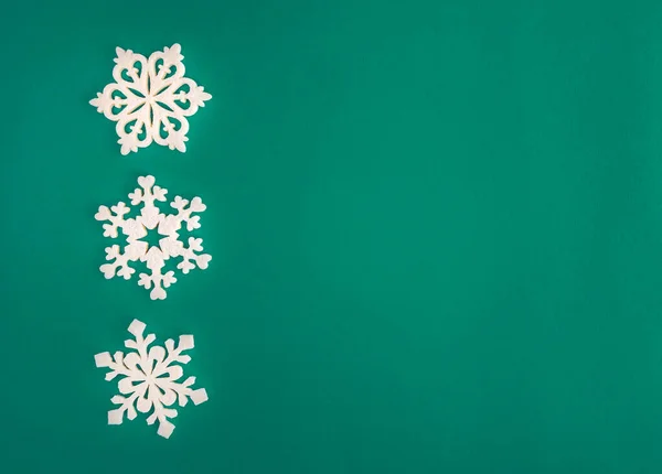 Kerstvakantie compositie, bovenaanzicht witte sneeuwvlokken decoratie op groene en aquamarijn achtergrond met kopieerruimte voor tekst. Plat gelegd. Winter, ansichtkaart template — Stockfoto