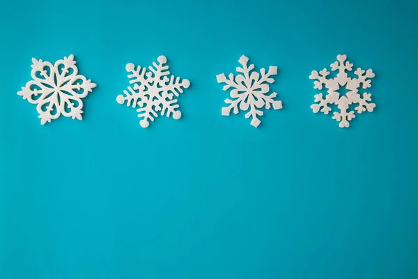 Composition vacances de Noël, vue sur le dessus décoration de flocons de neige blancs sur un fond bleu-aquamarin avec espace de copie pour le texte. Pose plate. Hiver, modèle de carte postale — Photo
