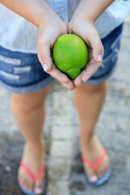 green turkish lemons in hands close-up.