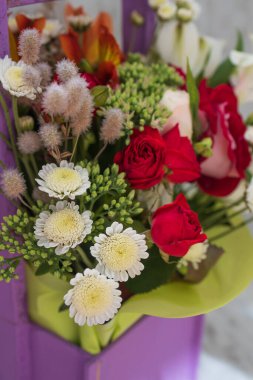 Beyaz arka planda mor bir sepetin içindeki güzel parlak buket, kopyalama alanı.