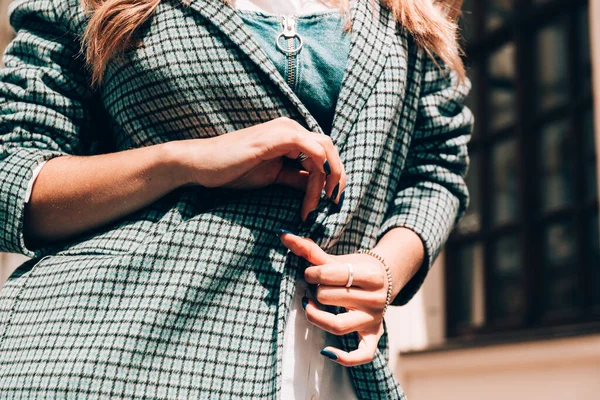 Hermosas manos femeninas con manicura azul y elemento de elegante abrigo a cuadros — Foto de Stock