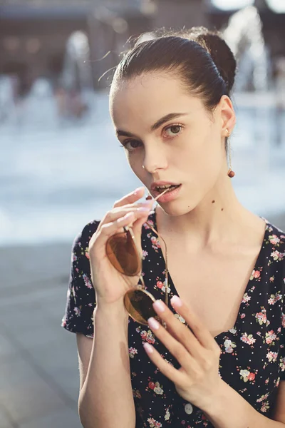 Ritratto di giovane donna alla moda. Bruna con acconciatura ballerina in prendisole in posa sulla strada. Focus selettivo — Foto Stock